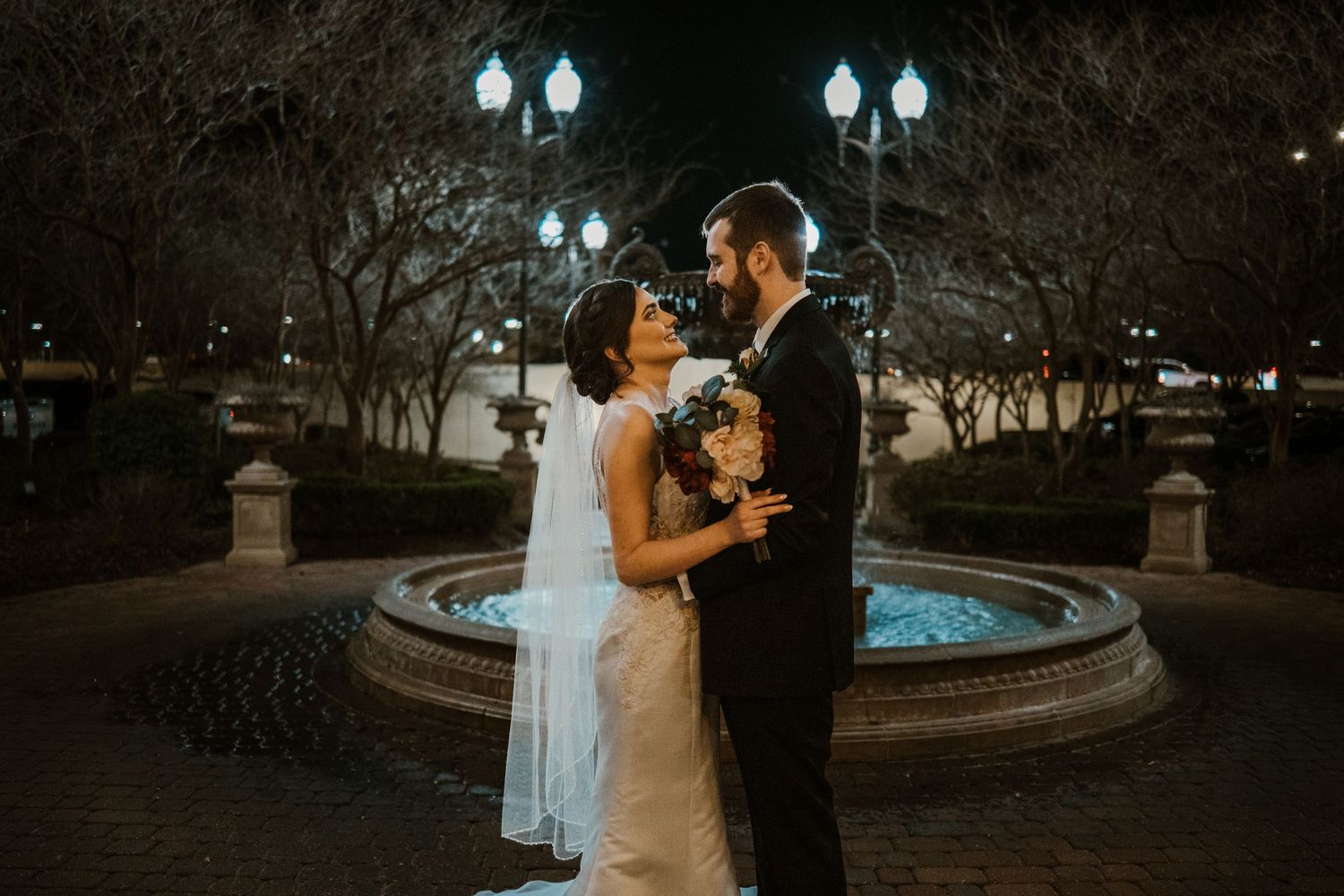 Bride and groom in front of backlit fountain Lafayette wedding venue