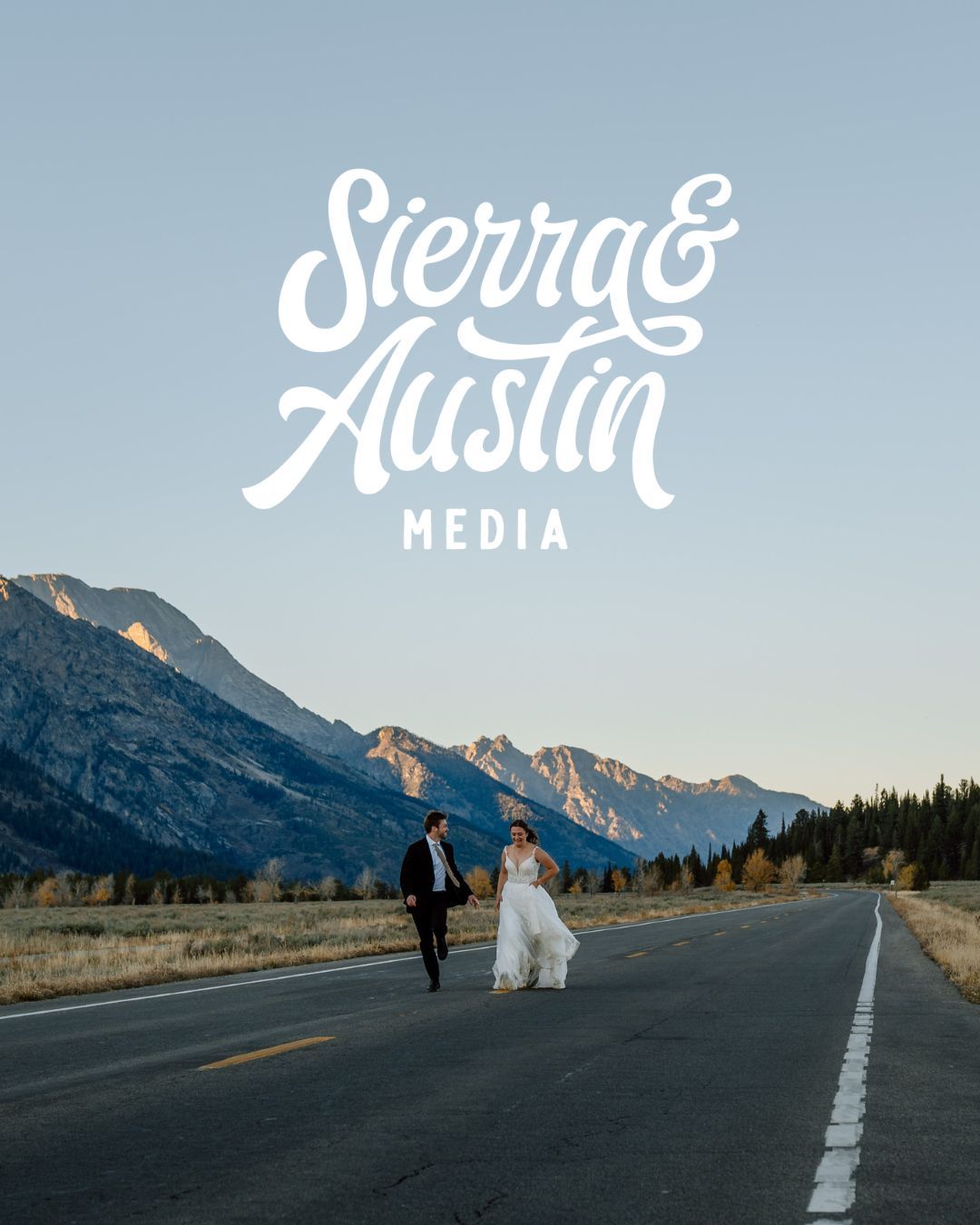 A couple walks on a mountain road at sunset with Sierra & Austin Media logo overlaid on blue sky.