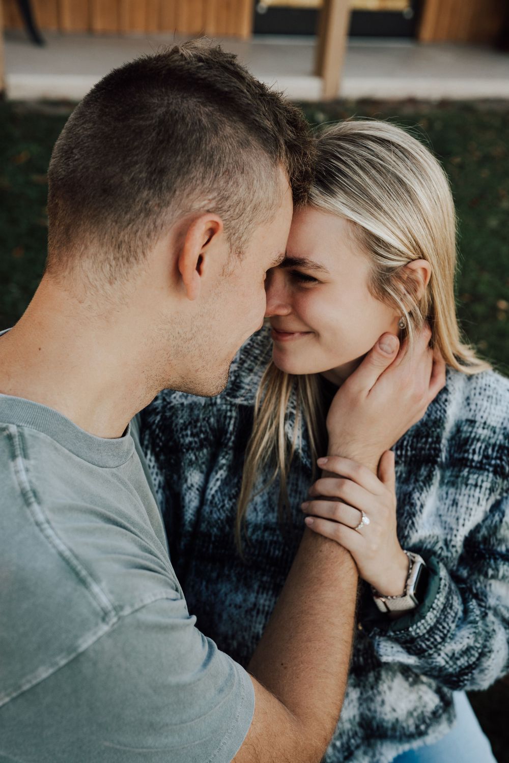 Intimate couple sharing a tender moment outdoors in casual attire.
