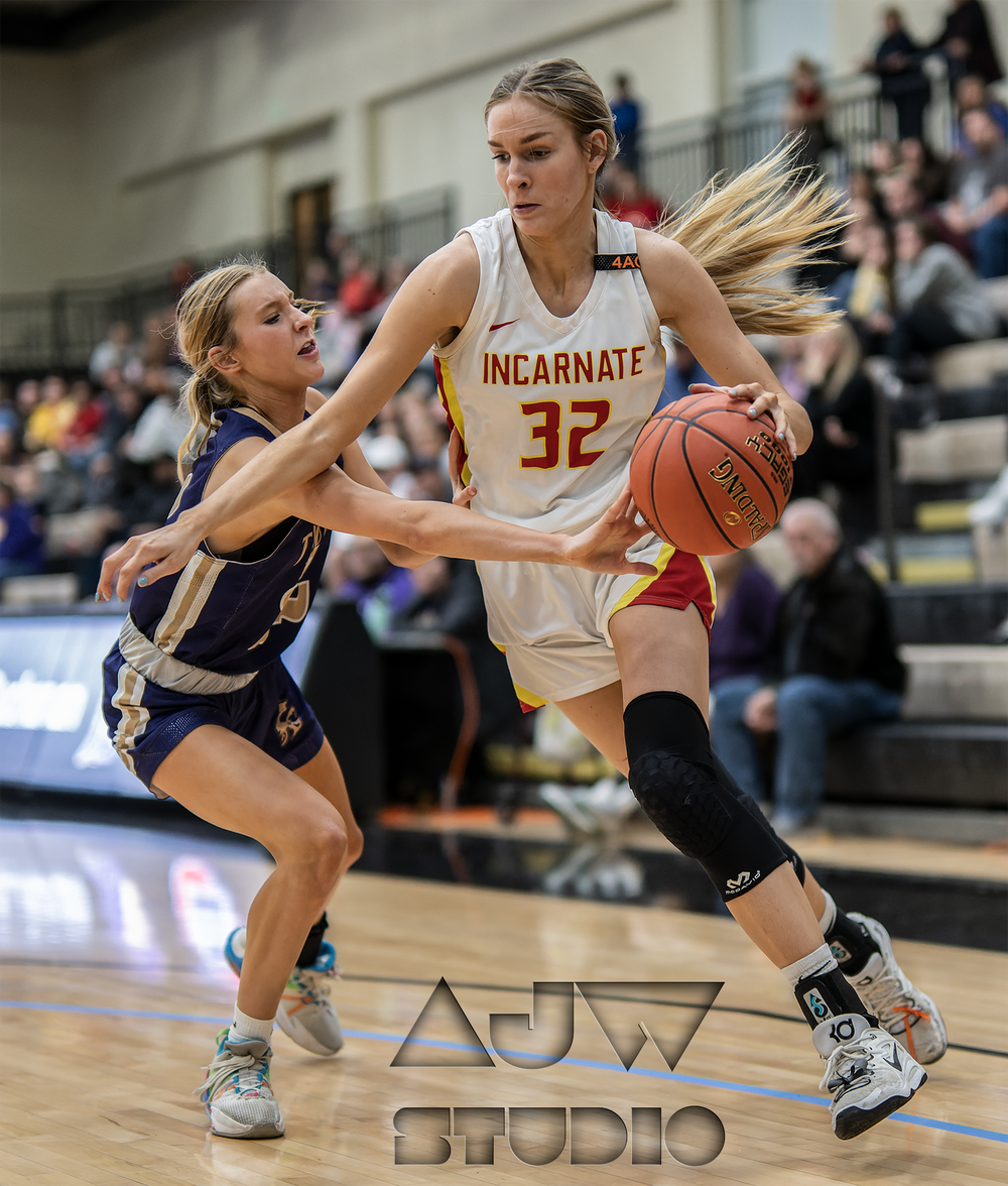 Women's basketball players battle for possession during competitive game.