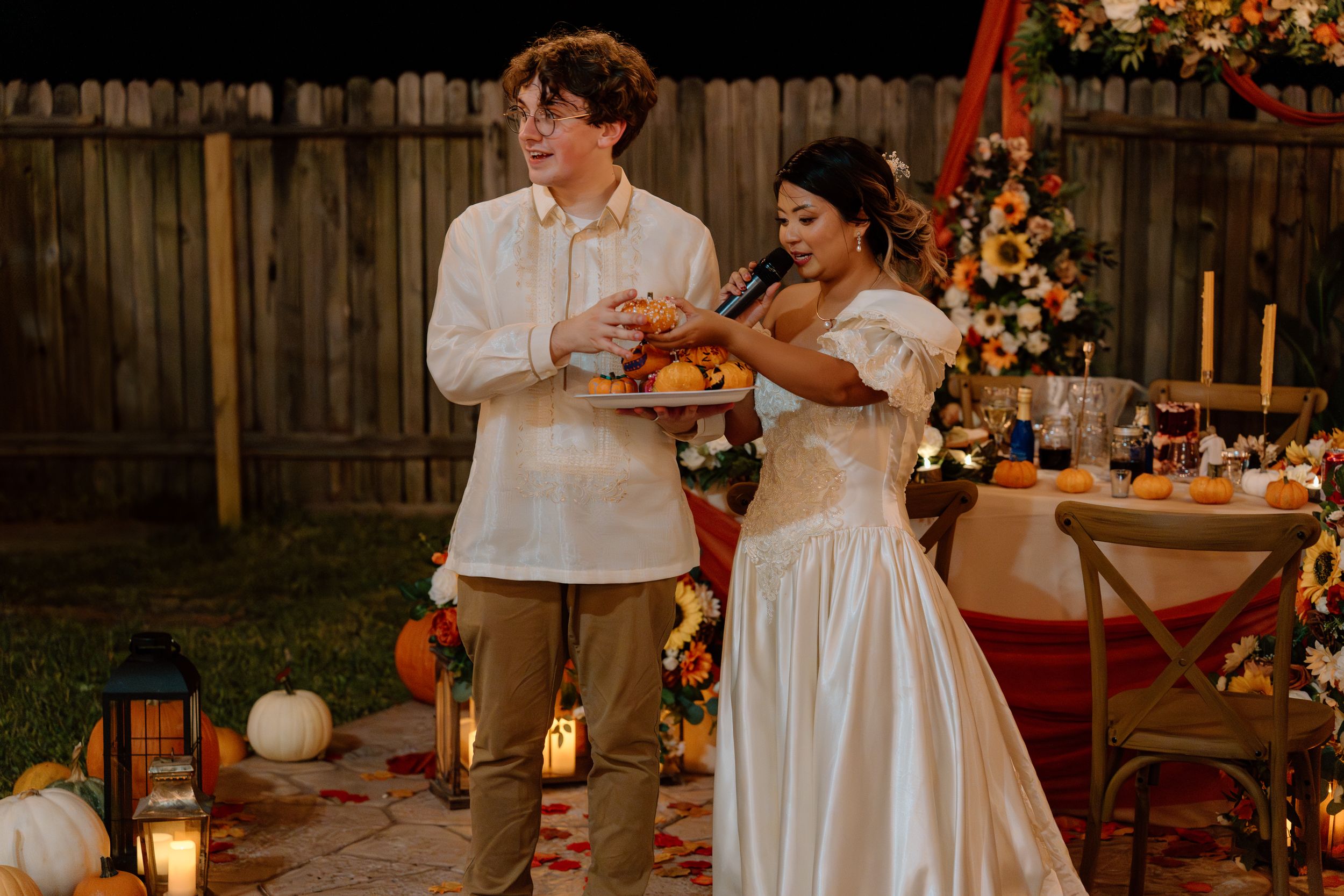Couple sharing a playful moment at their fall-themed outdoor wedding reception.