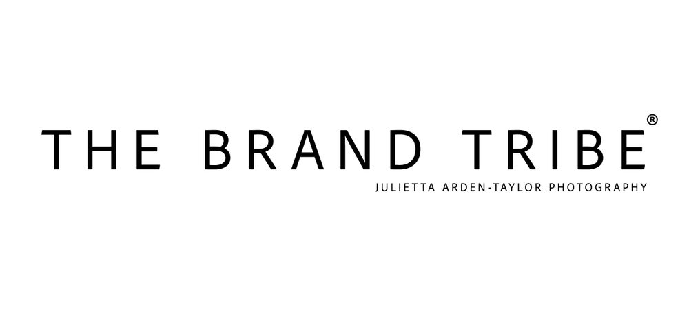 Modern black text logo for The Brand Tribe with minimal geometric styling and sleek typography.