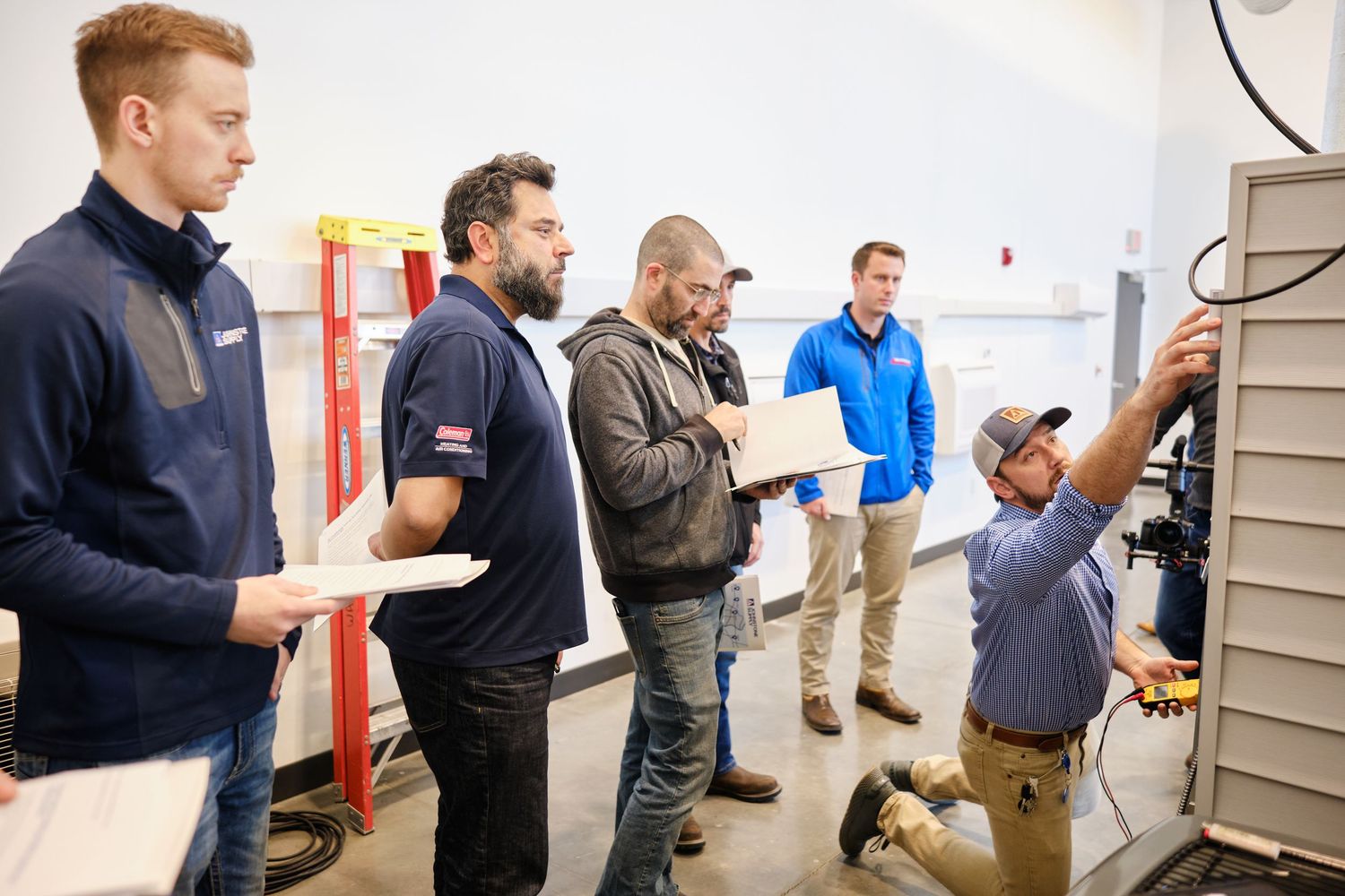 A group of technicians observing electrical equipment installation during a training or inspection session.