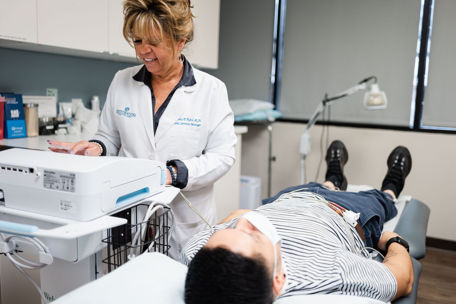 A healthcare professional in a white coat examines a patient during a medical consultation in a modern clinic setting.