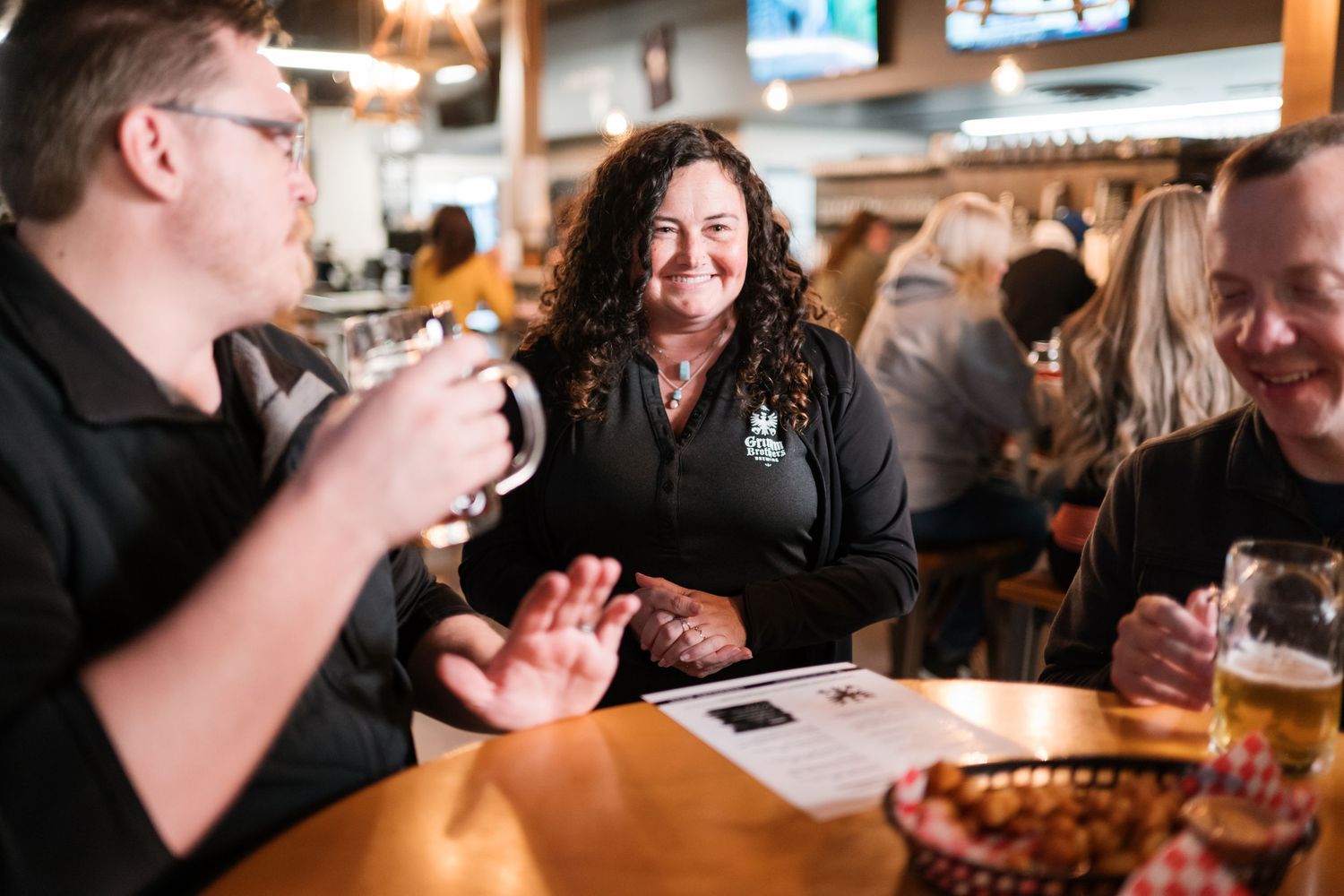 A group of friends enjoying a casual meal and drinks at a bustling pub or restaurant.