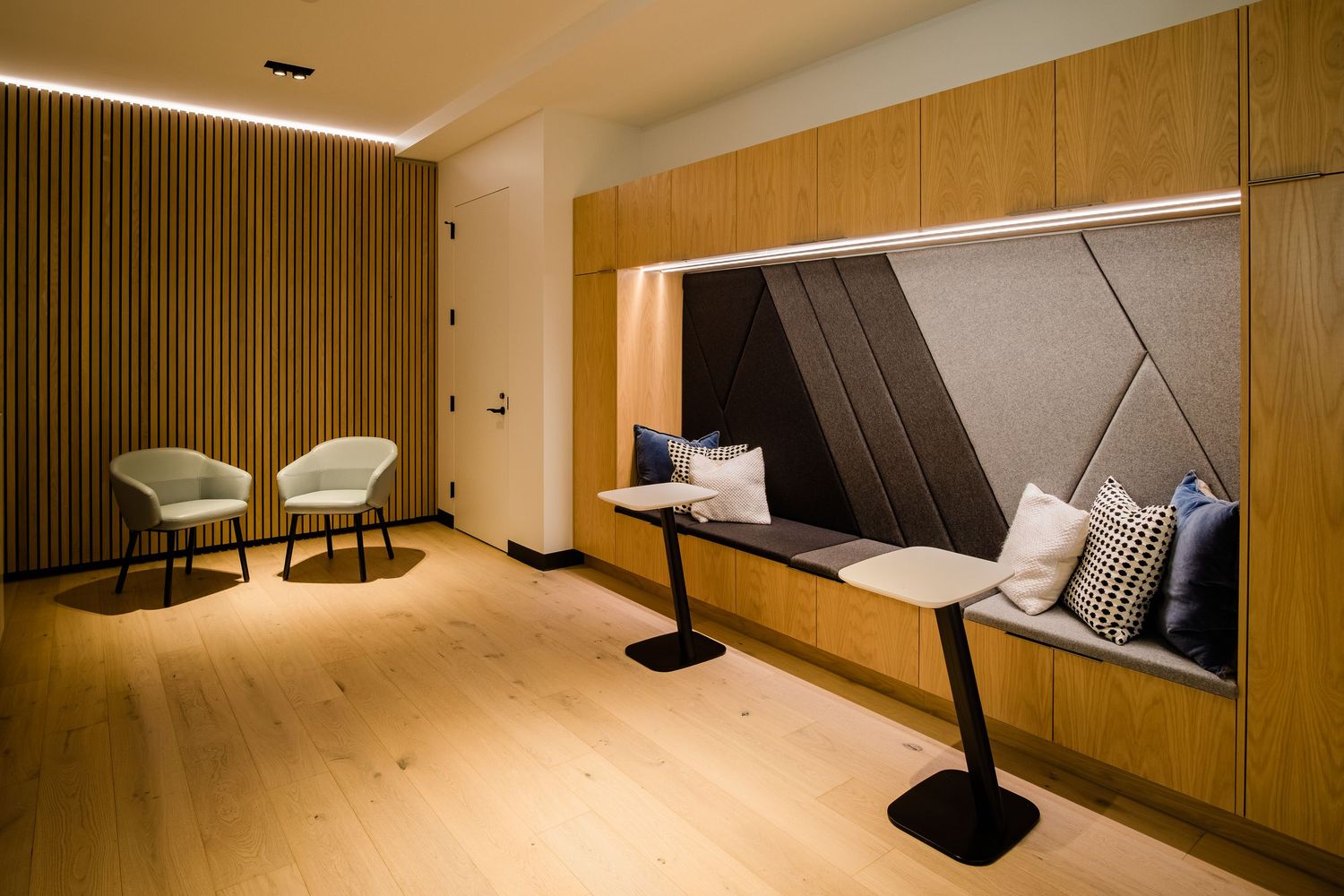 Minimalist interior hallway with wood paneling and modern pendant lighting fixtures.