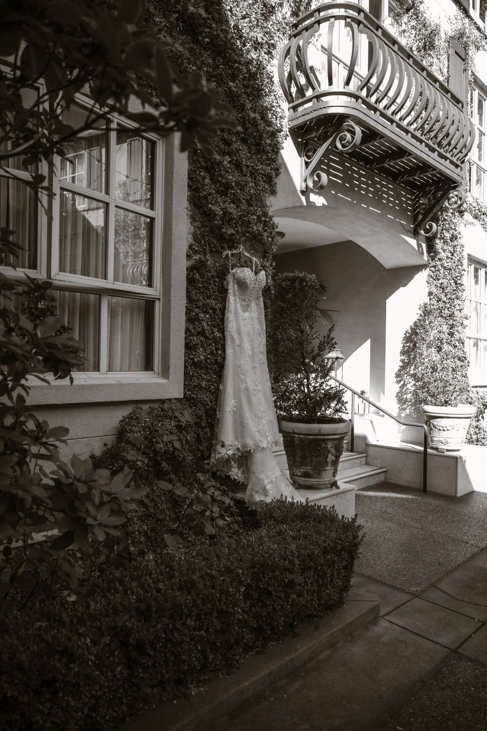 Black and white series of a wedding dress displayed against garden architecture.