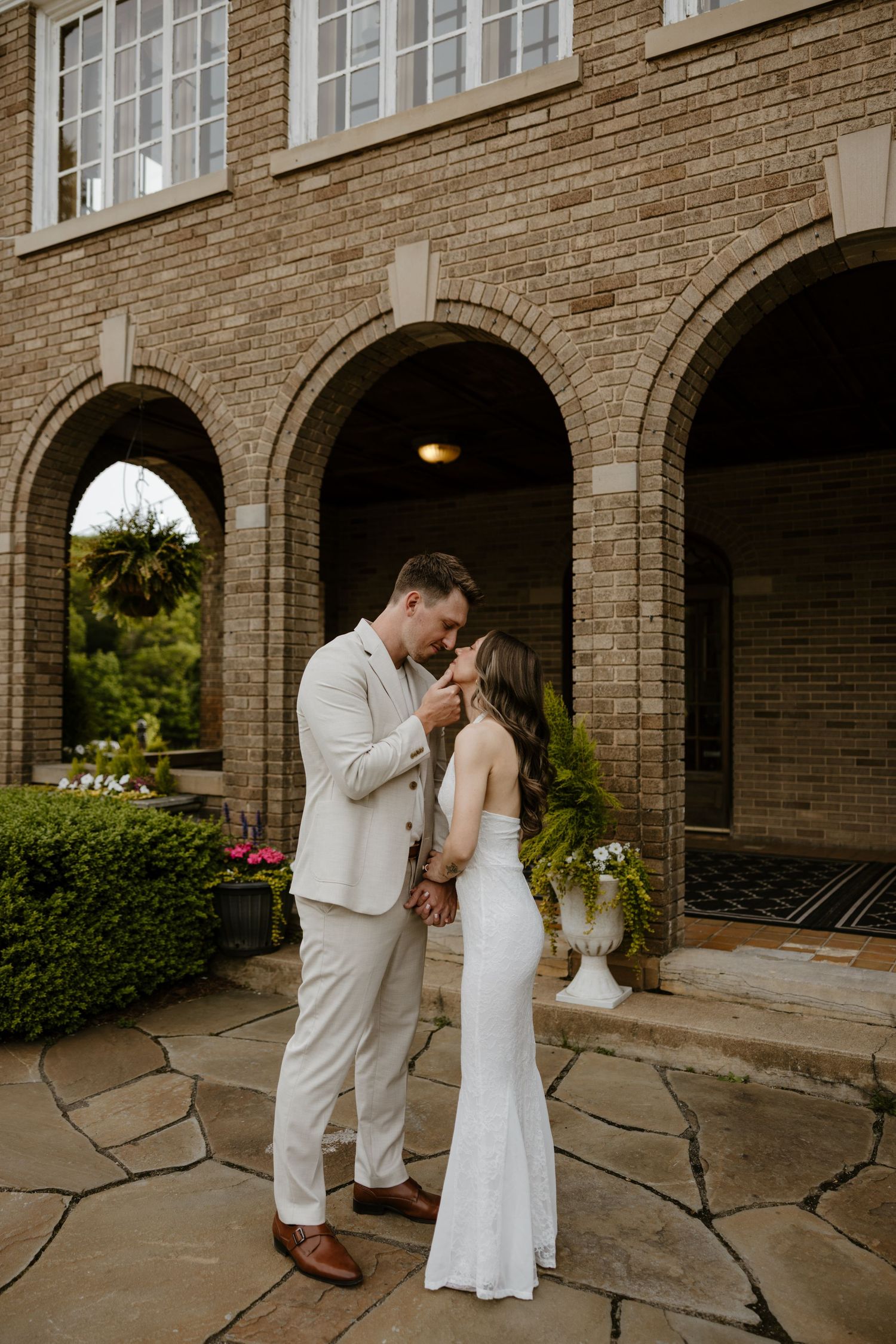 A black and white image showing a man and woman walking together on a brick path outside a building. Fort Worth Texas wedding photographer.