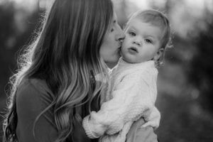 Intimate black and white portrait of tender moment between parent and baby.