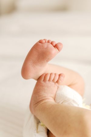 Close up of tiny newborn baby feet in soft natural lighting.