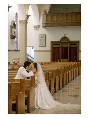 Romantic moment between couple in church pews with elegant architecture.