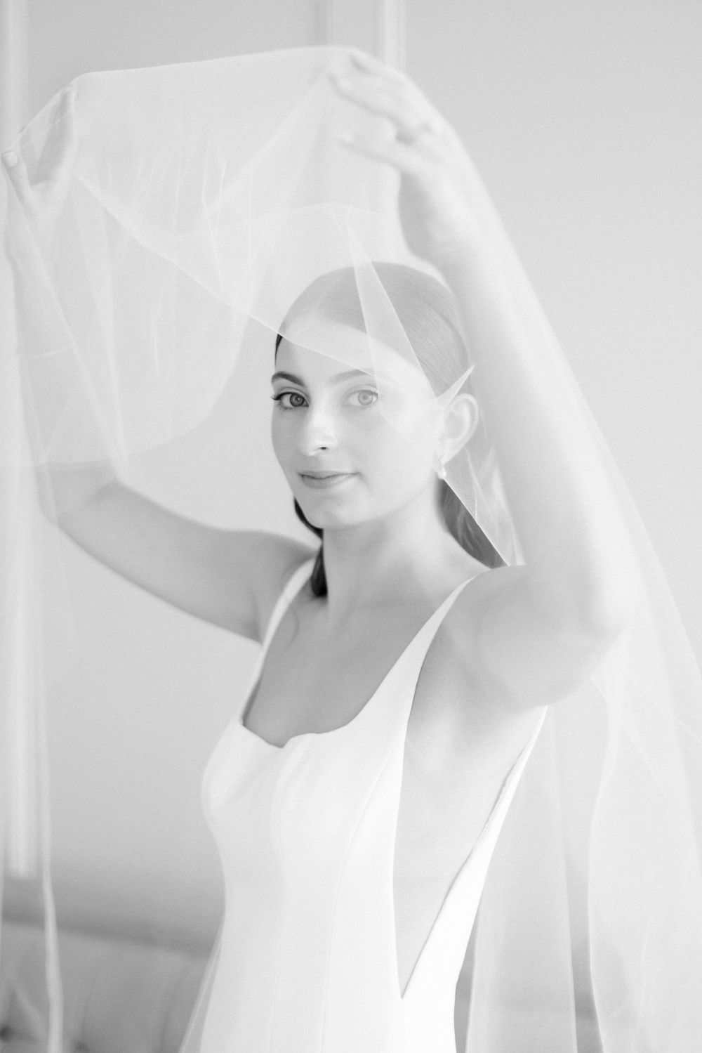 Ethereal black and white bridal portrait with flowing veil.