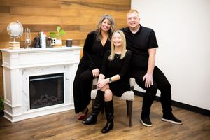 Contrasting black and white styled photos show a modern living room with wood floors and fireplace mounted on wall.