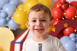 Multicolored balloon arch installation with red, yellow, and blue balloons against a warm-toned background.