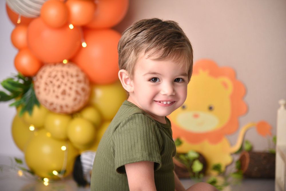 Festive party setup with orange and yellow balloon decorations featuring a lion theme backdrop.