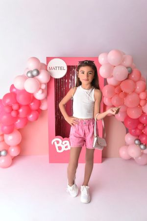Pink ombre balloon garland arrangement against light colored wall for party backdrop.