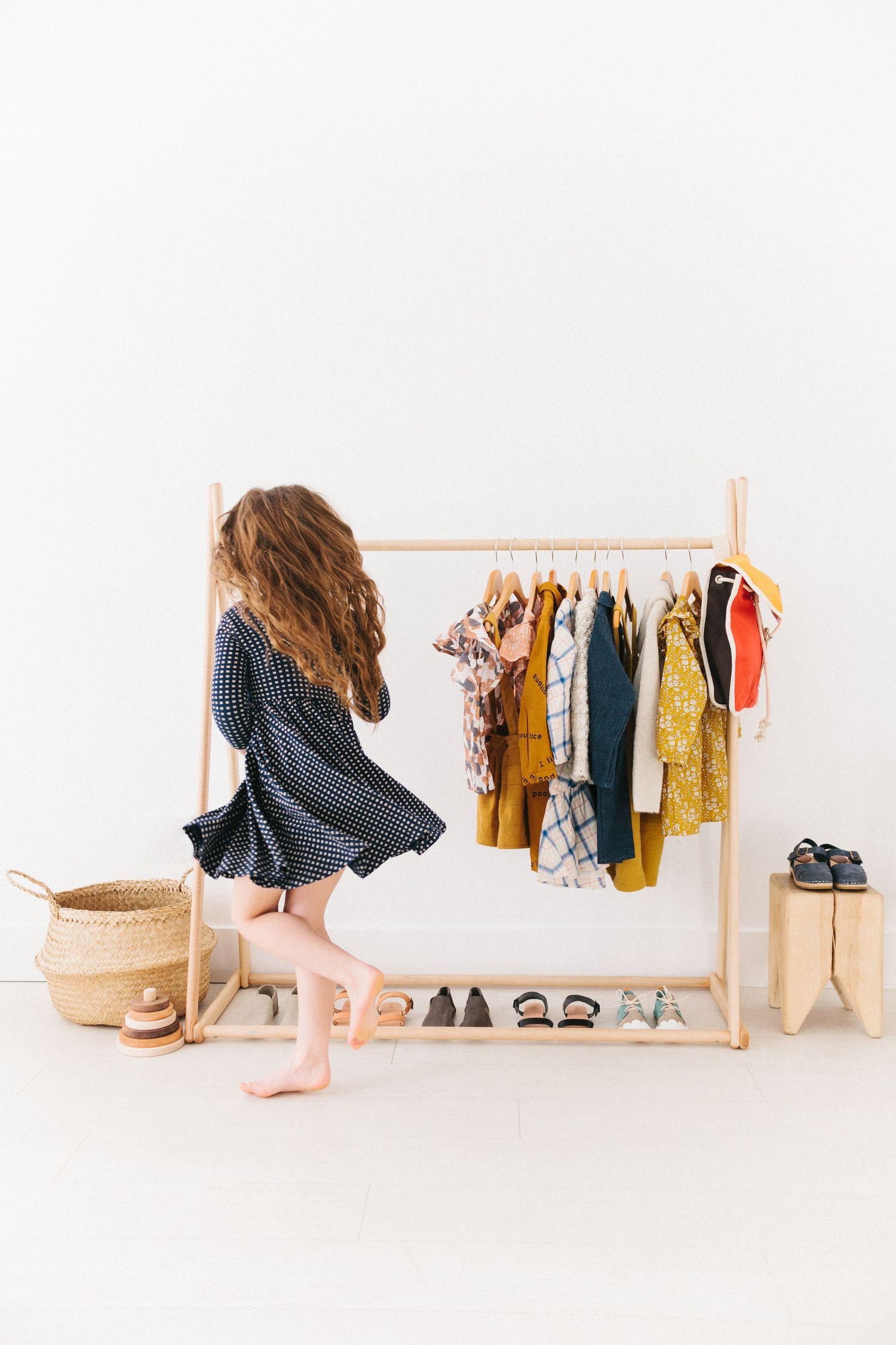 little girl twirling in a dress in front of a clothes rack