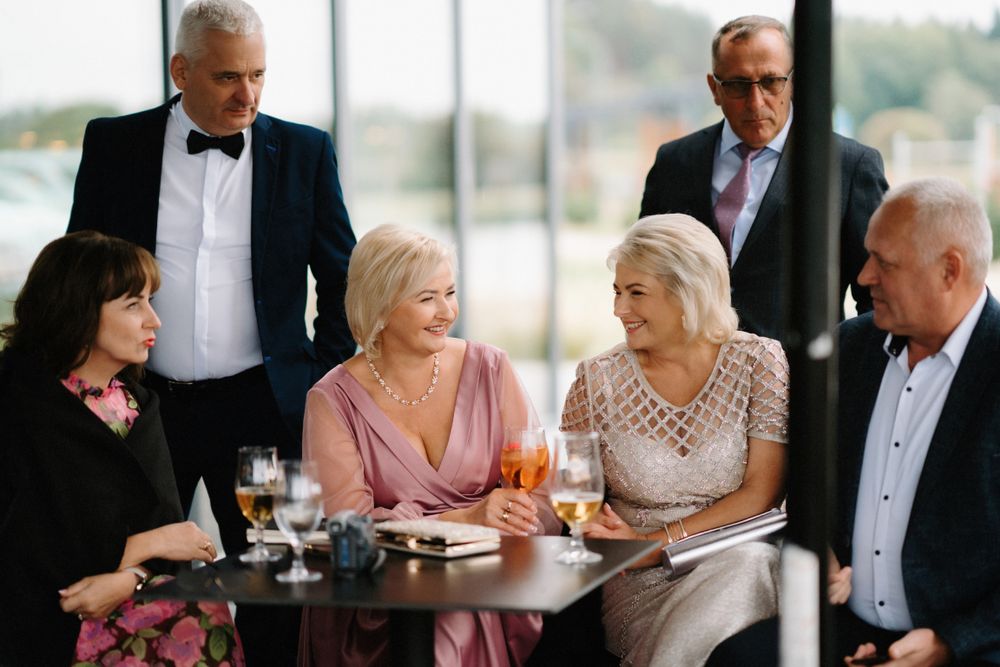 Wedding guests enjoying conversation at elegant dining tables during a formal reception.