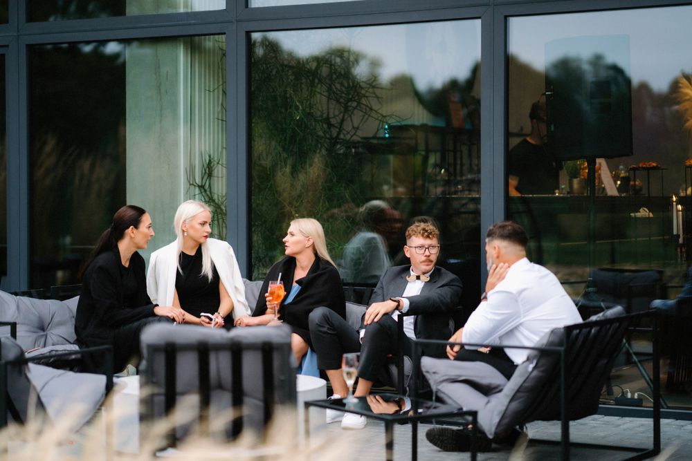 Modern reception venue with floor-to-ceiling windows and guests seated at dining tables.
