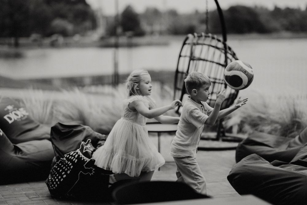 Black and white photo of wedding guests socializing at a formal dining event.