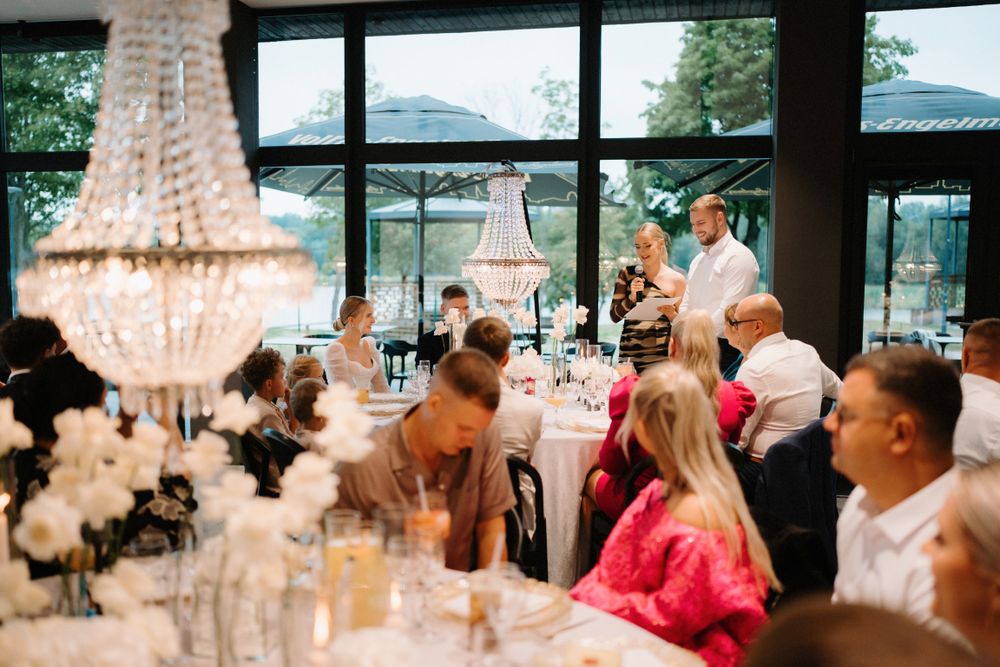 Crystal chandeliers hanging above dining tables at an upscale wedding reception venue.