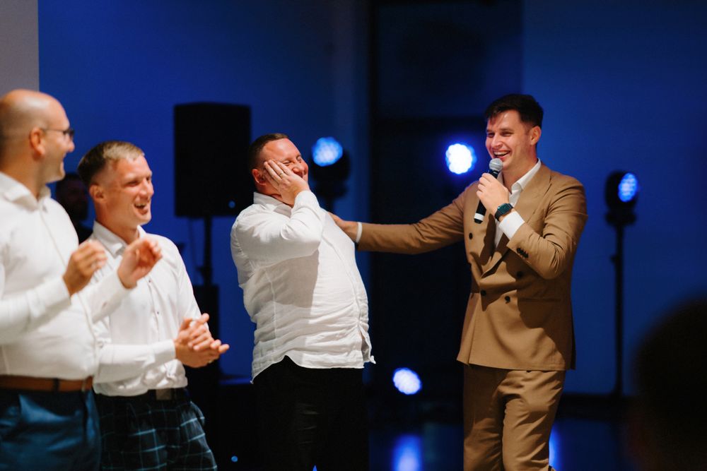 Energetic dance floor moments captured in dramatic blue lighting at a wedding reception.