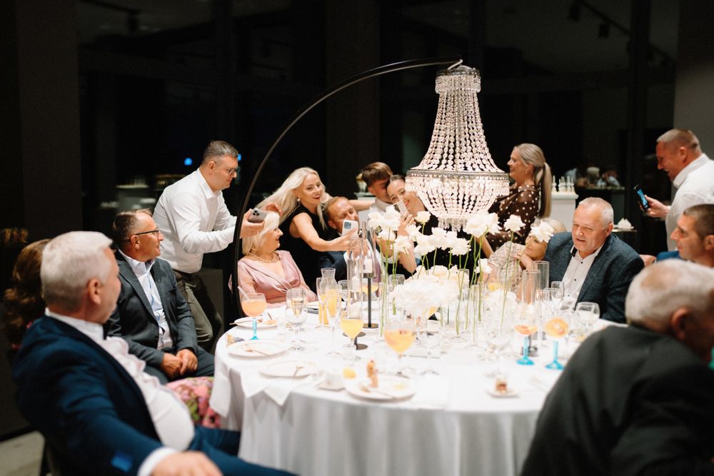 Wedding reception venue with round tables and crystal chandeliers creating an elegant atmosphere.