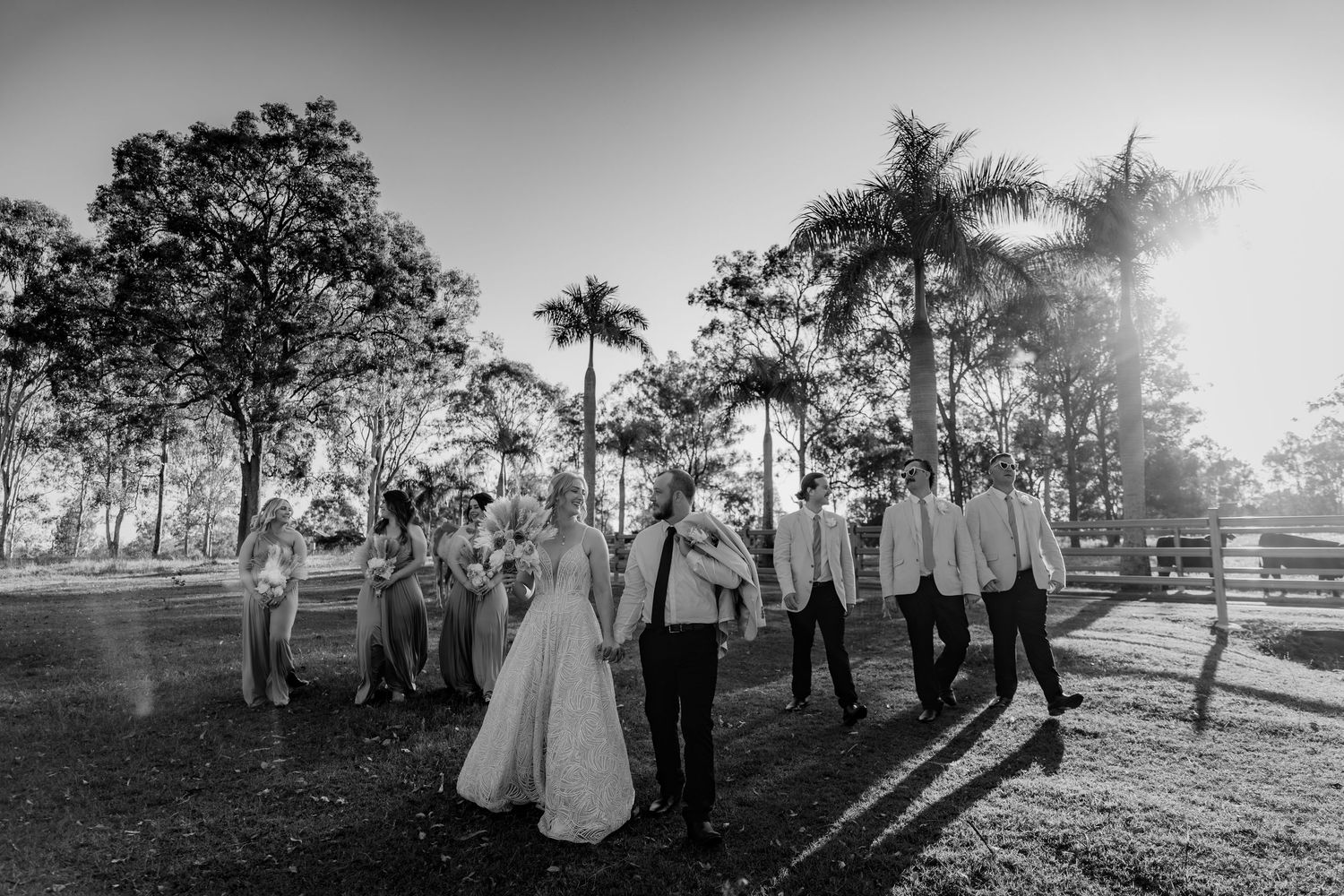 Black and white panorama of wedding ceremony gathering at rustic outdoor venue.