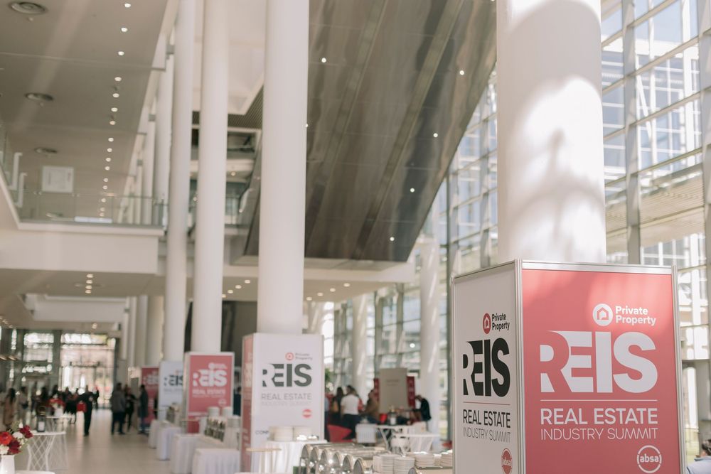 REIS Real Estate Industry Summit banners displayed in modern conference venue.