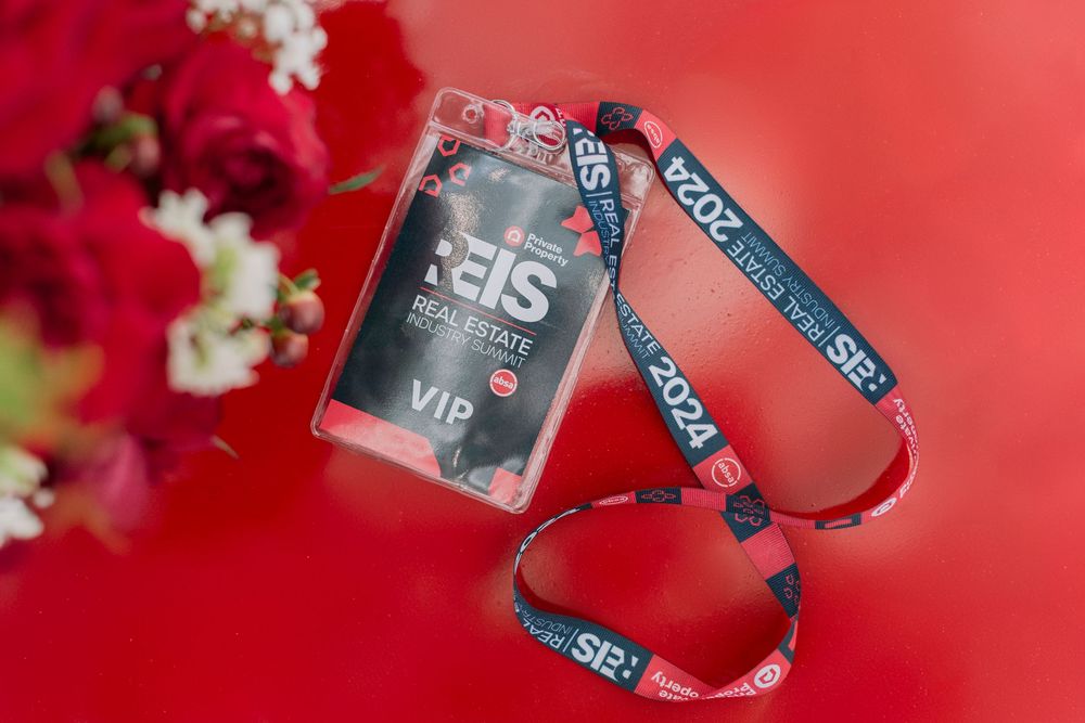 REIS 2024 VIP lanyard badge on red background with flowers.