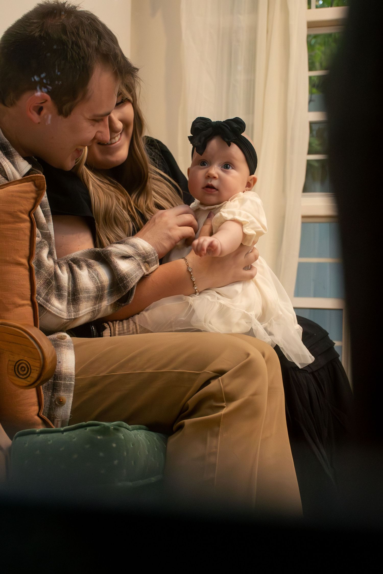 Tender family moment on a couch showing affectionate interaction in warm lighting in American Fork, Utah.