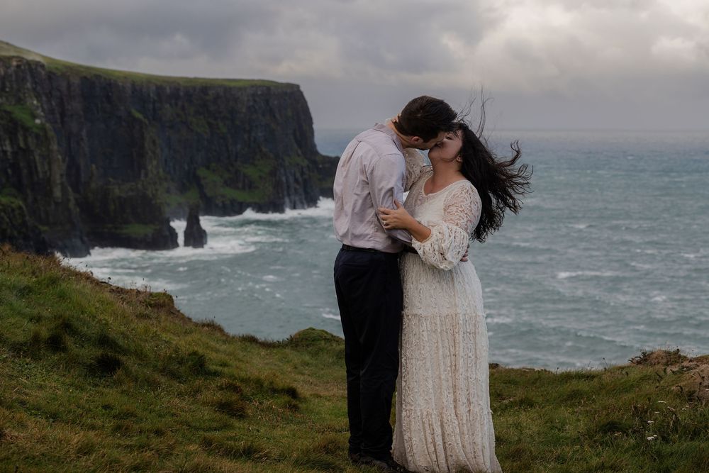 Couple lkissing during sunrise elopement at Cliffs of Moher