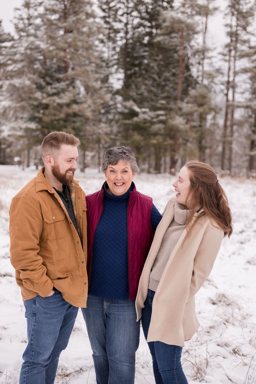 Family members sharing laughter and embraces during a winter photo session.