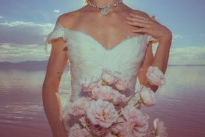 A collage of wedding dress details showing white ruffles and floral embellishments against a blue sky backdrop.
