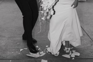 A series of black and white wedding photos showing close-ups of feet and formal shoes on a dance floor.