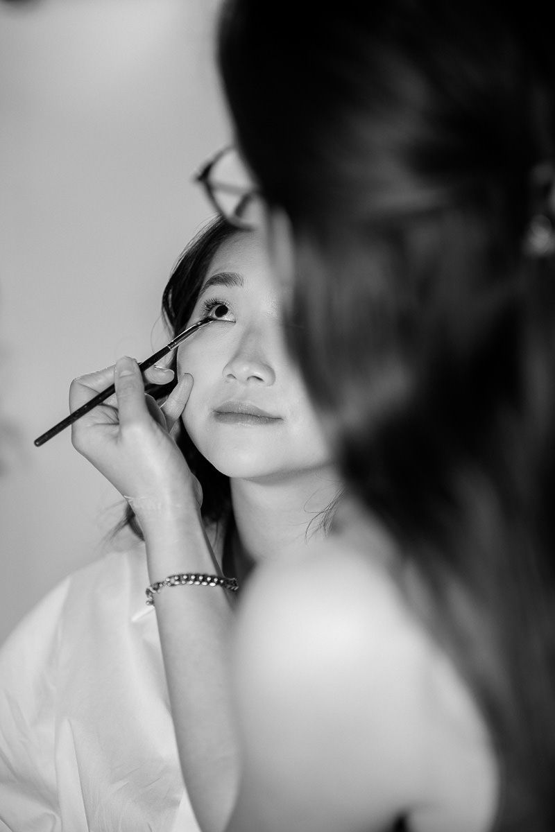 Black and white photo series showing the application of makeup with brushes in an artistic beauty styling sequence.