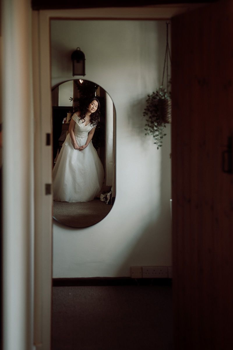 A sequence of artistic black and white wedding photos showing reflections in mirrors with moody lighting.