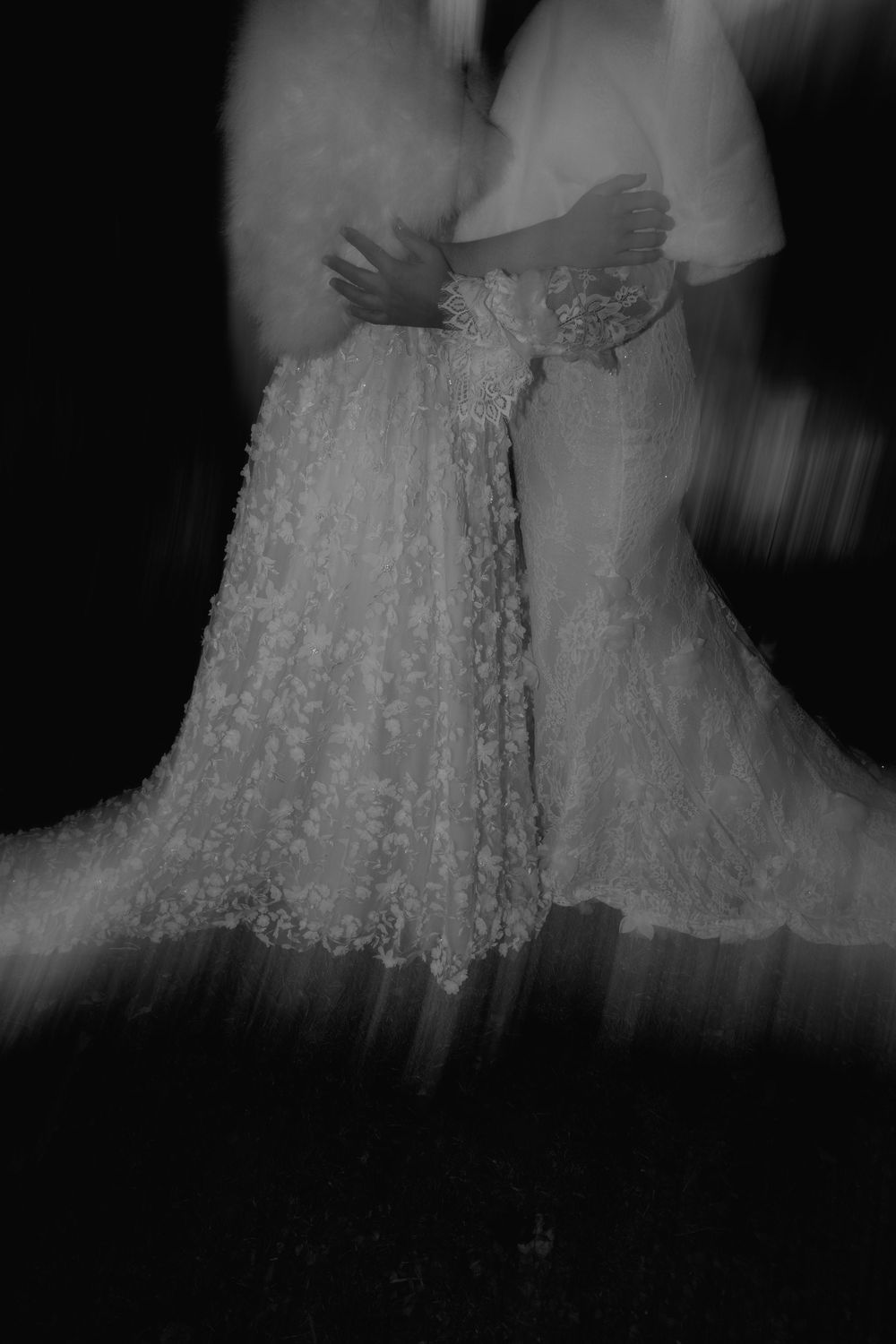 A series of blurry black and white photographs showing a wedding dress with delicate lace details and flowing fabric.