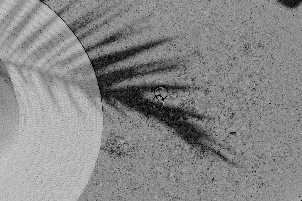 A black and white photograph of a rocky surface with shadows and textures visible in the monochromatic detail.