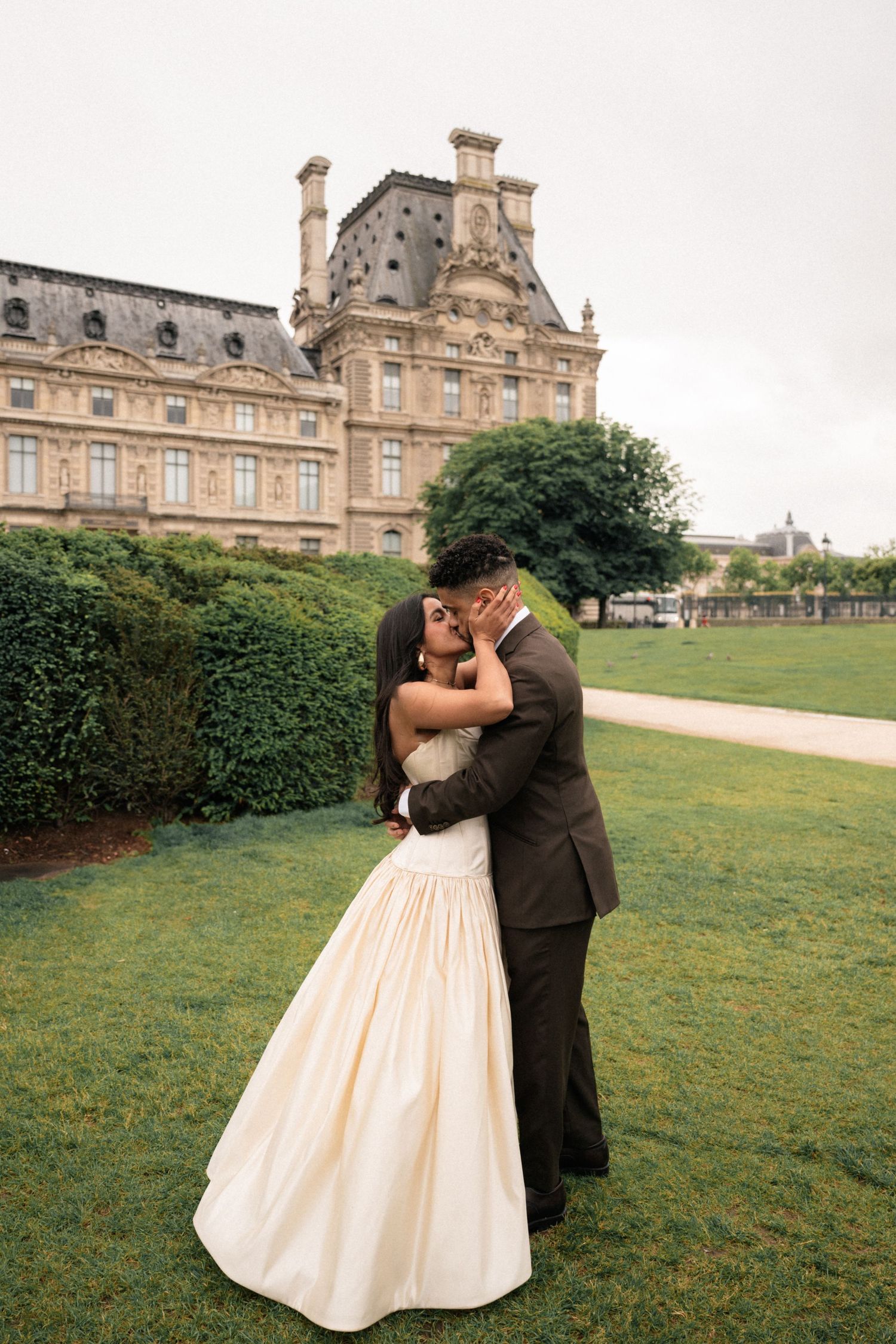 A romantic wedding couple shares intimate moments on the lawn of a grand European chateau in multiple candid shots.