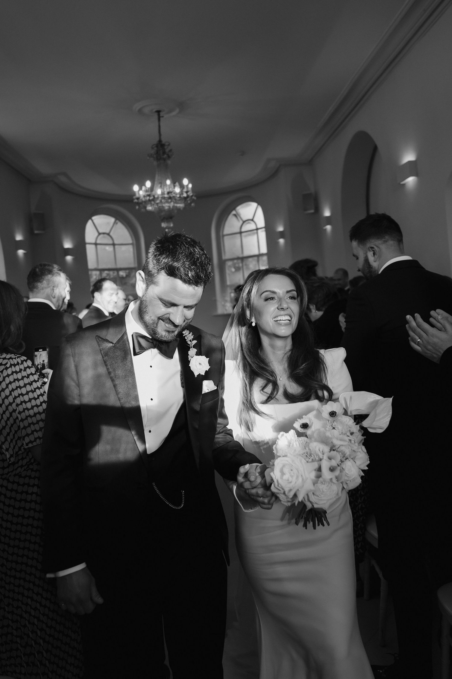 bride and groom coming down aisle as husband and wife as their guest cheer for them at Iscoyd park