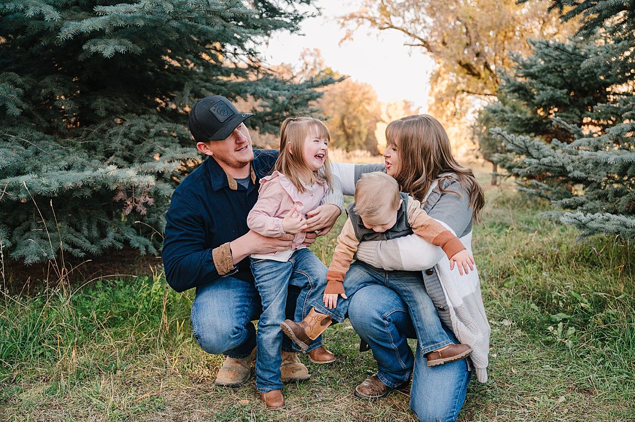 Candid family moments captured during outdoor photoshoot with pine trees in background.