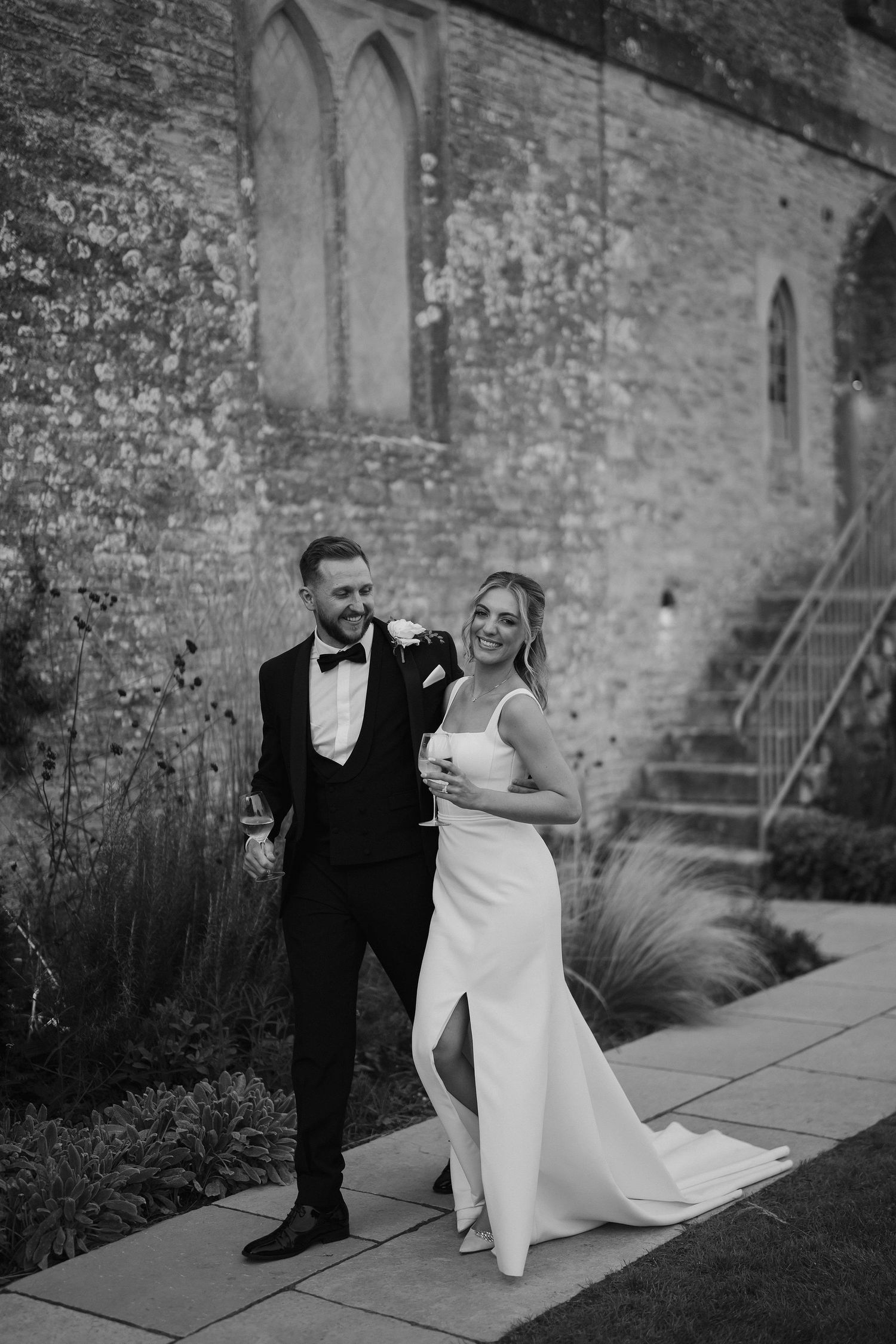 bride and groom walking and smiling at ivy lodge wedding in cirencester