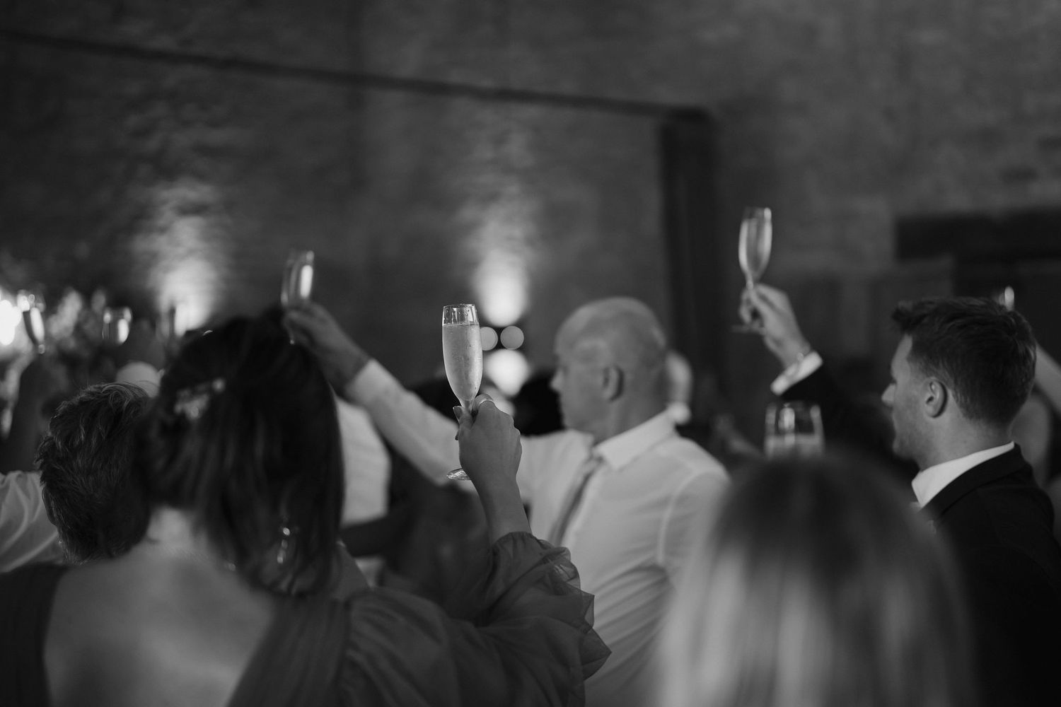 wedding guests toasting with champagne at end of wedding speeches at ivy lodge in cirencester
