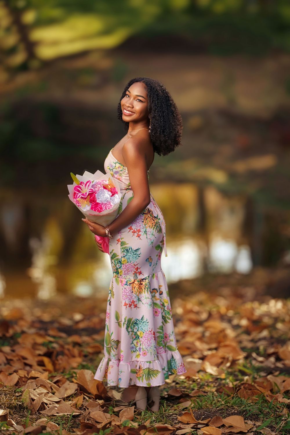 A joyful figure in a floral dress twirls and plays among fallen autumn leaves in a sunlit outdoor setting.