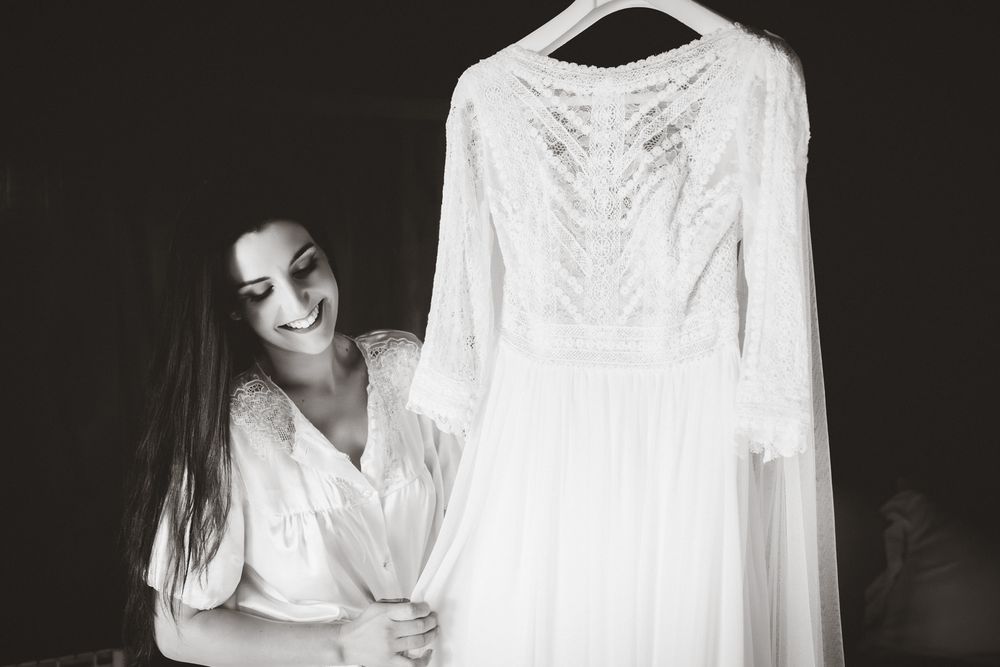 Novia observando su vestido de novia colgado durante los preparativos de la boda.