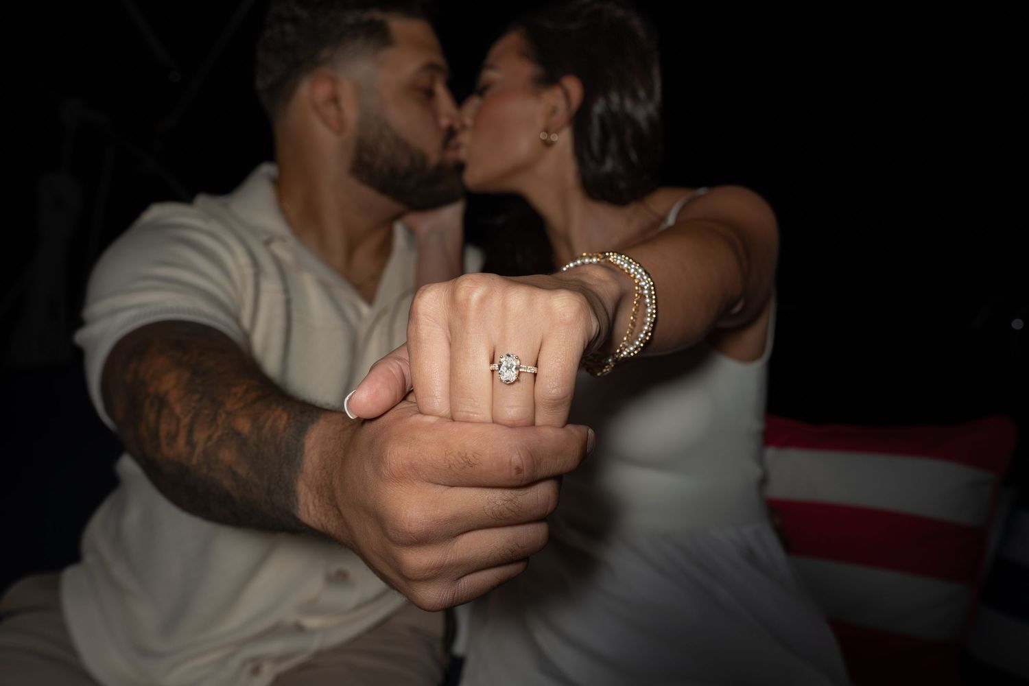 Two people share an intimate moment dancing together in a dimly lit setting.