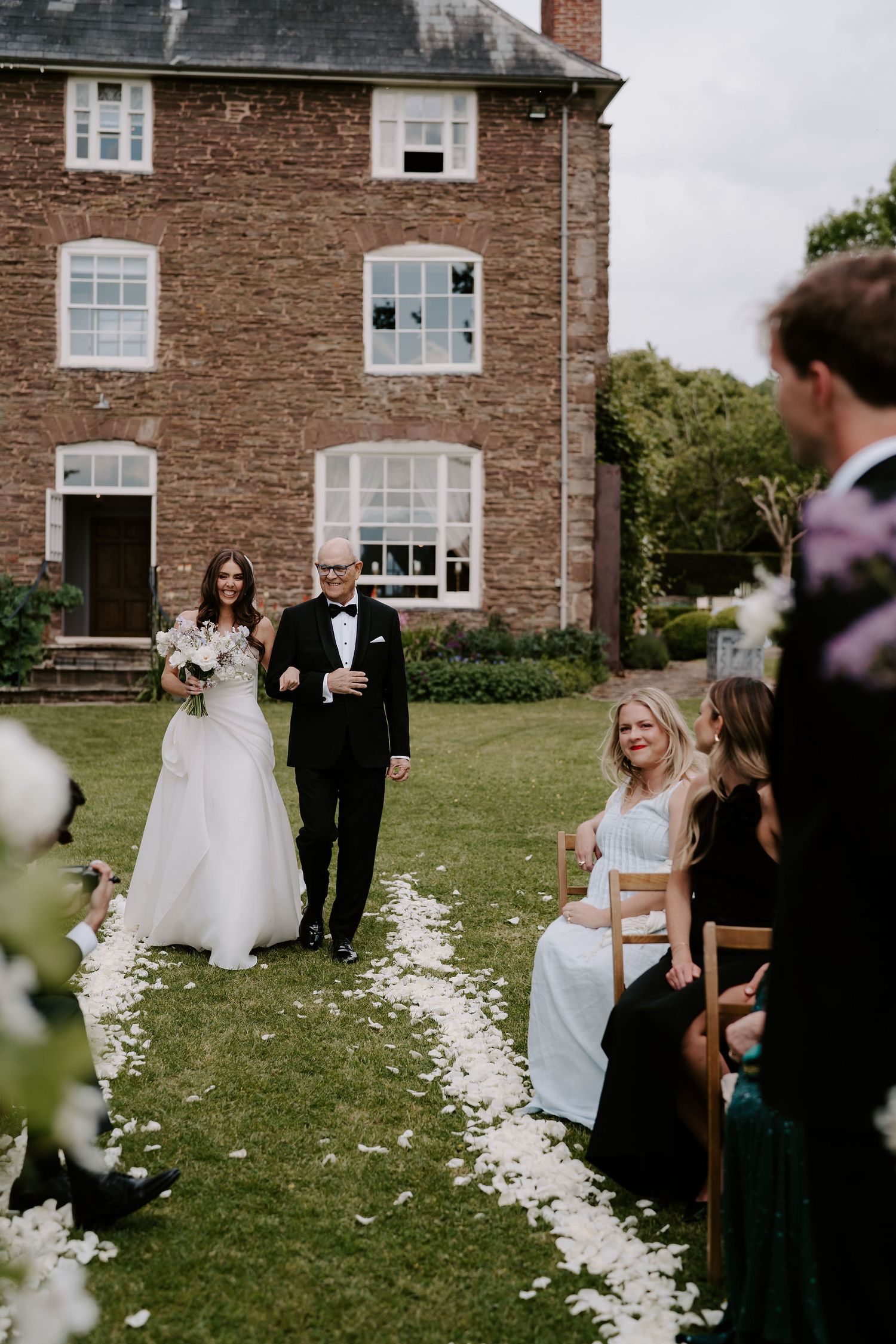 bride and dad walking down the aisle to the groom at dewsall court in herefordshire