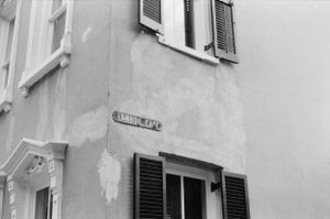 Black and white architectural detail of building corner with street sign.