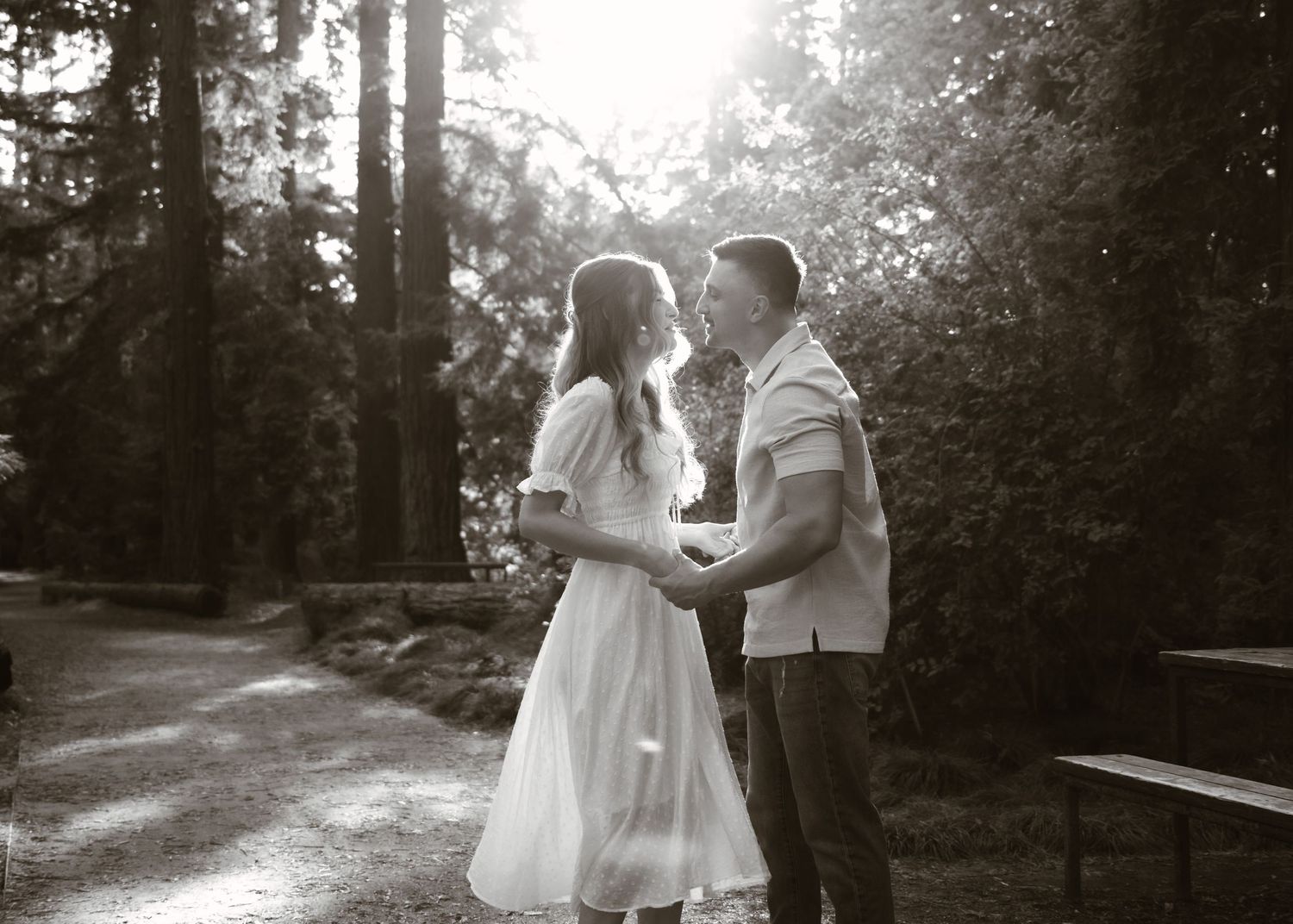 A black and white series of romantic moments in a sunlit forest setting.